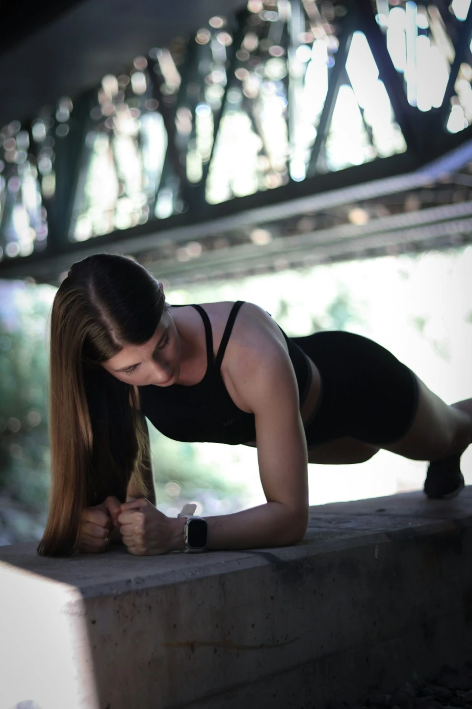 A woman in a black top is doing a push up